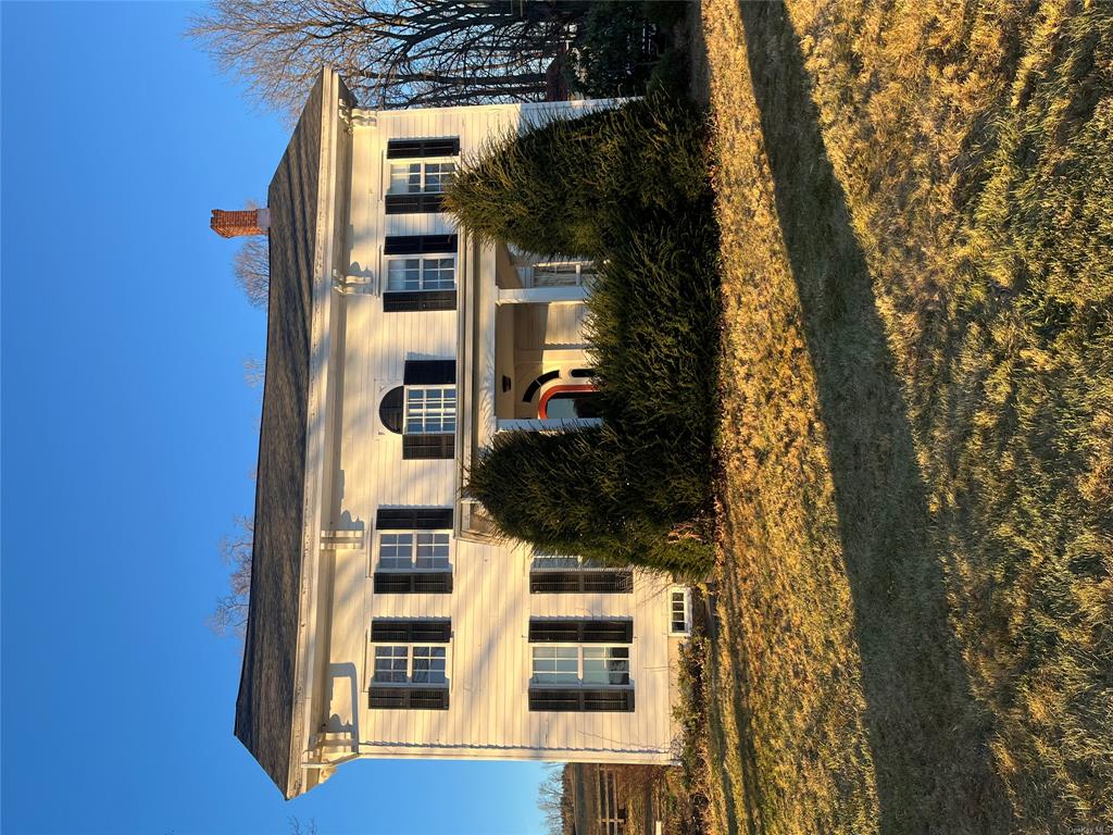 a view of a white house with a yard