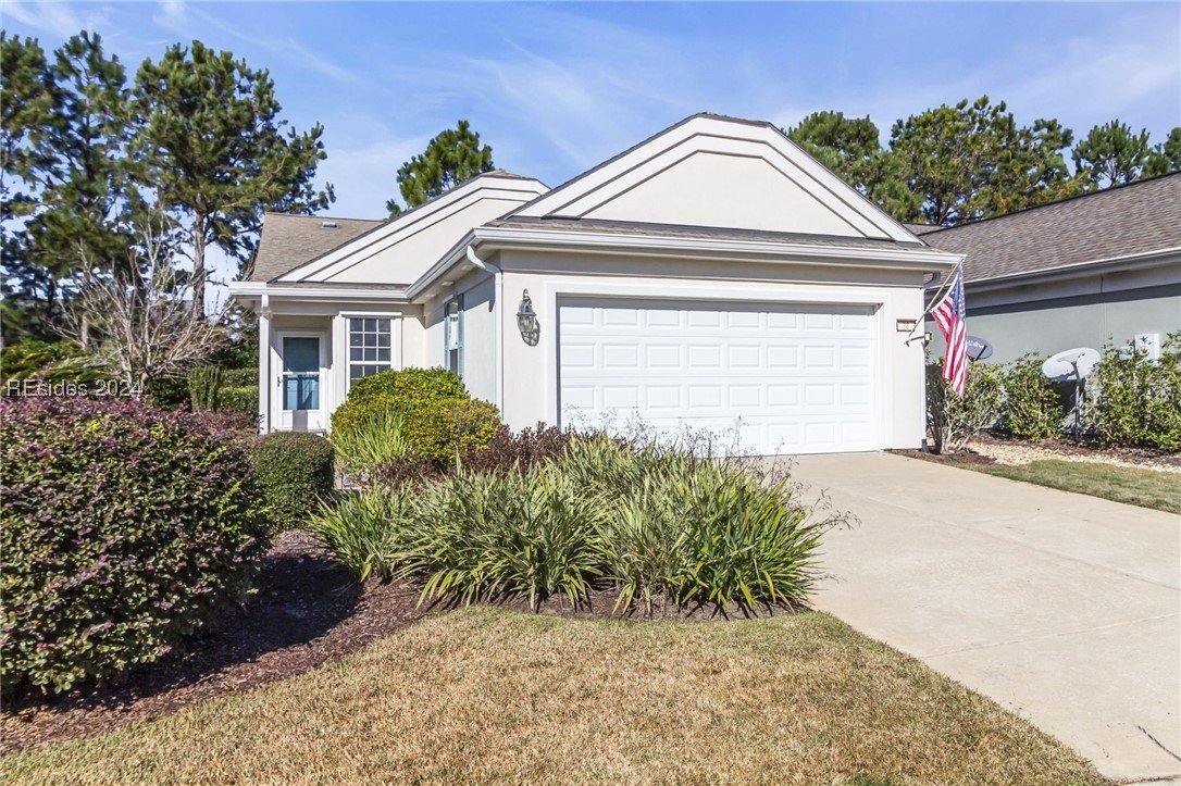 Single story home featuring a garage and a front y