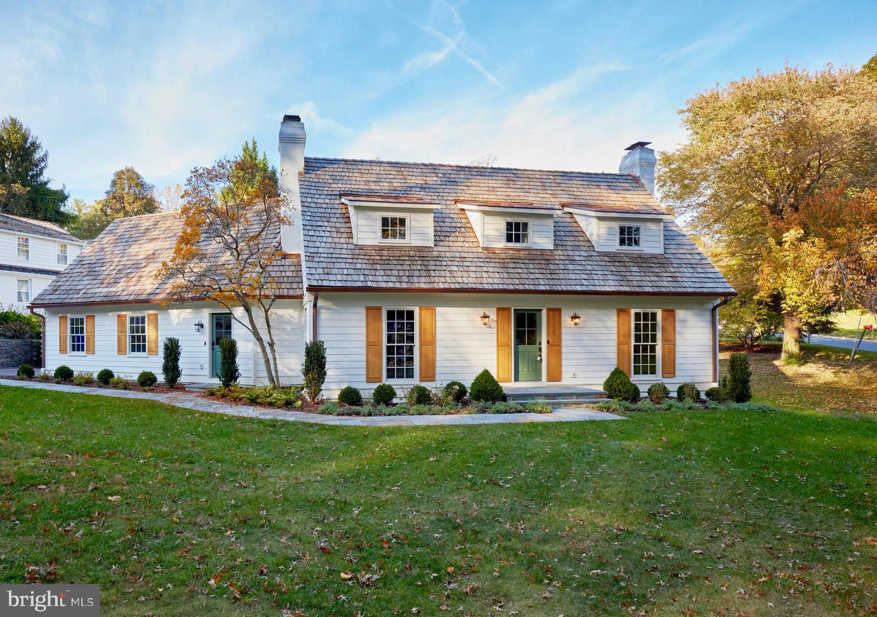 a front view of a house with a yard and trees