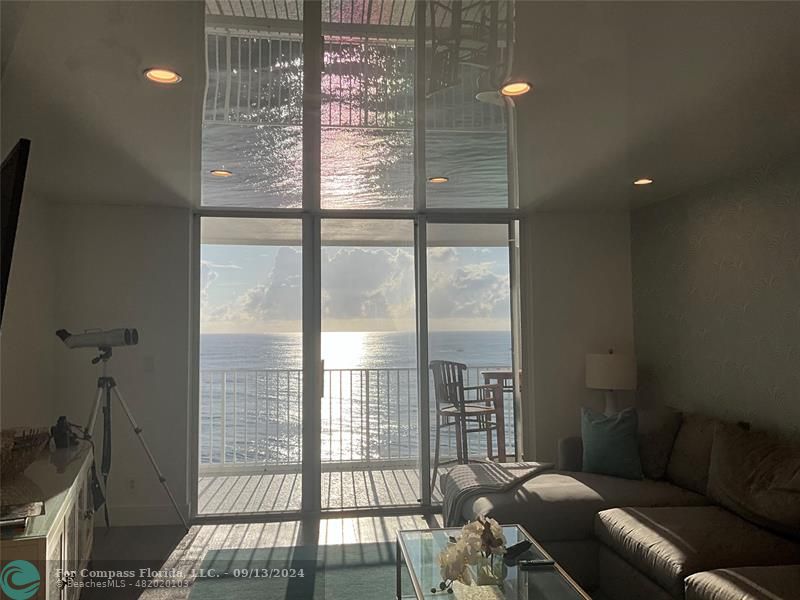 a living room with furniture and a floor to ceiling window