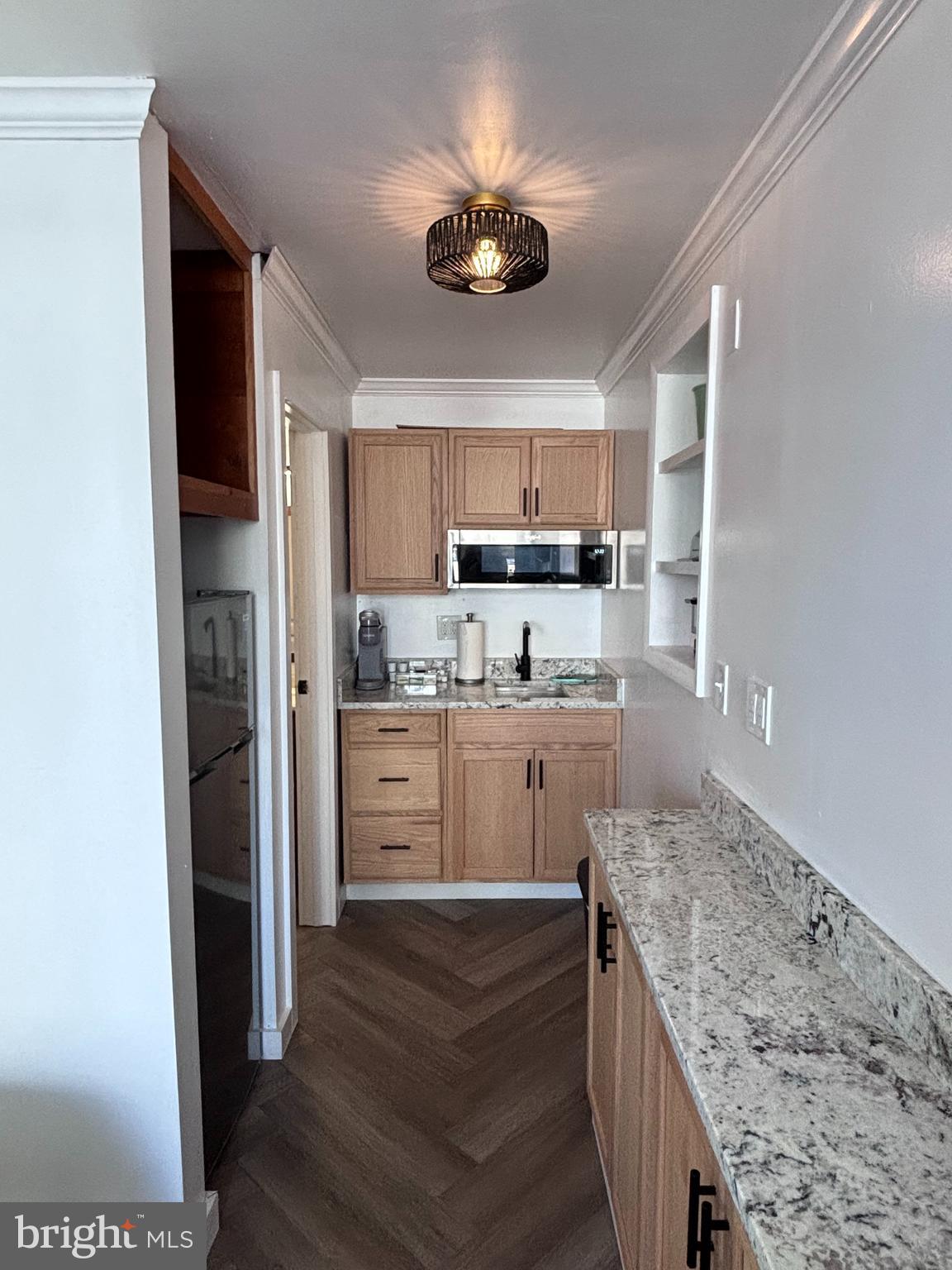 a kitchen with kitchen island a counter top space a sink stainless steel appliances and cabinets