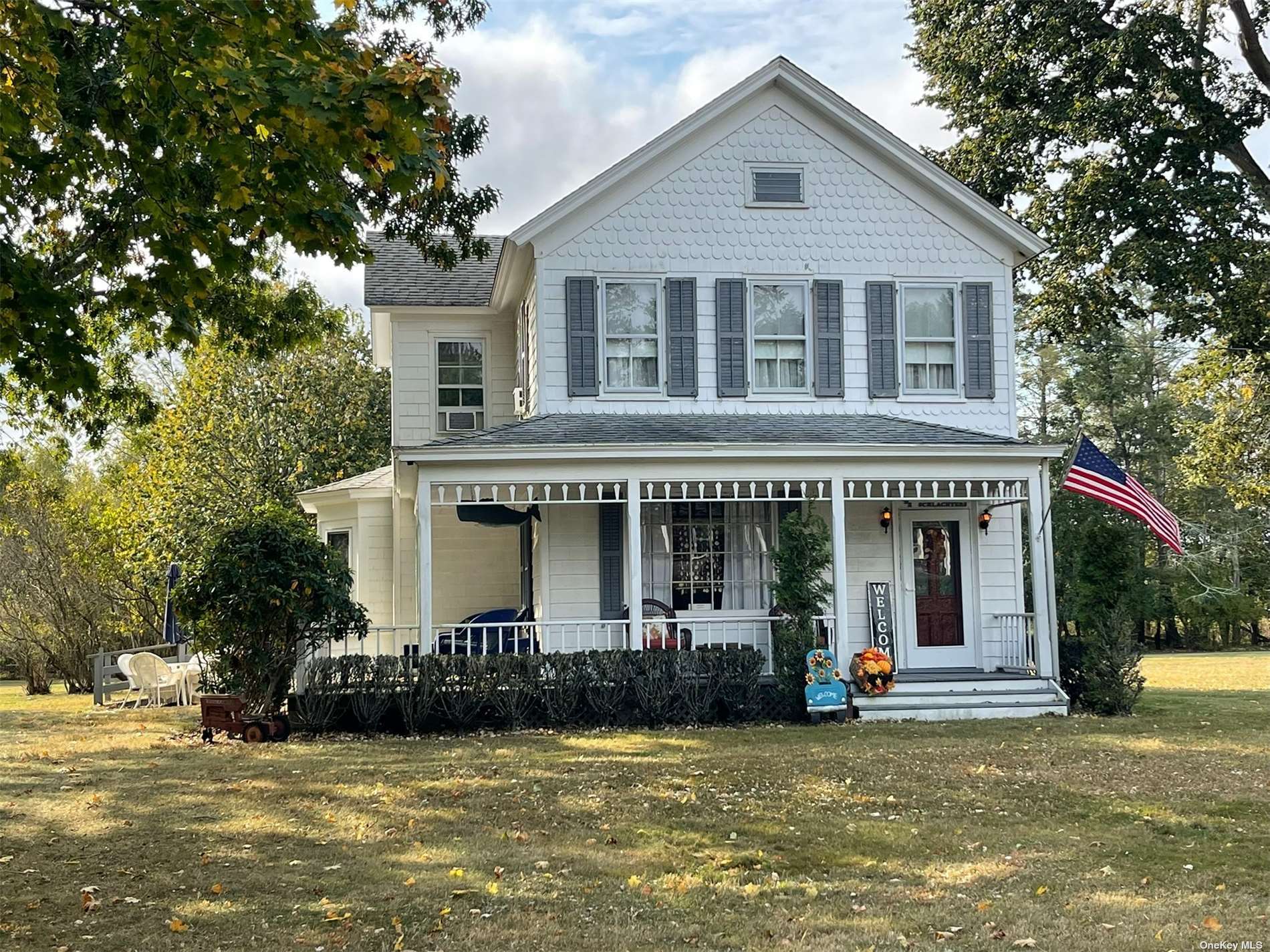 a front view of a house with a garden and trees