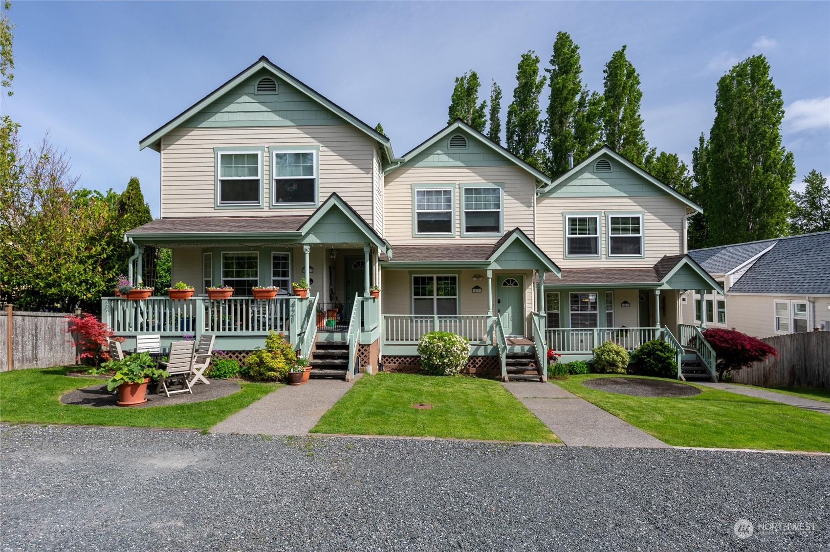 a front view of a house with a yard and potted plants