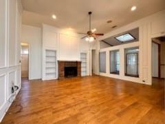 a view of an empty room with a fireplace and a chandelier fan