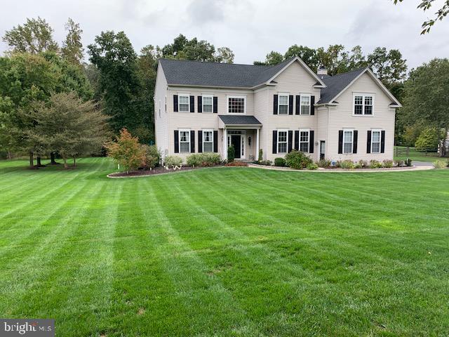 a view of a house with a big yard and large trees