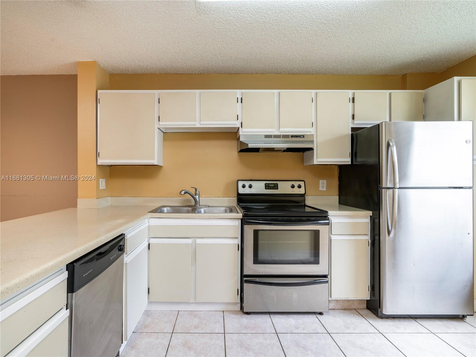 a kitchen with a sink a stove and a refrigerator