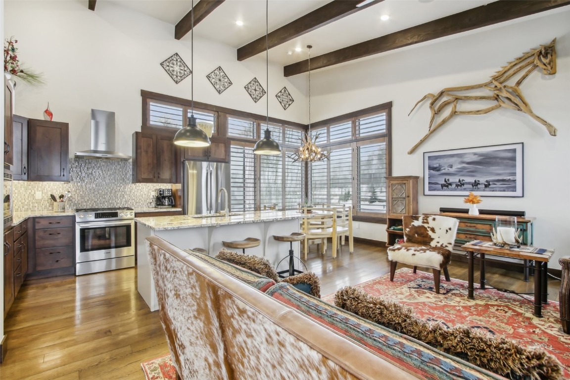 a very nice looking living room with a large window and stainless steel appliances