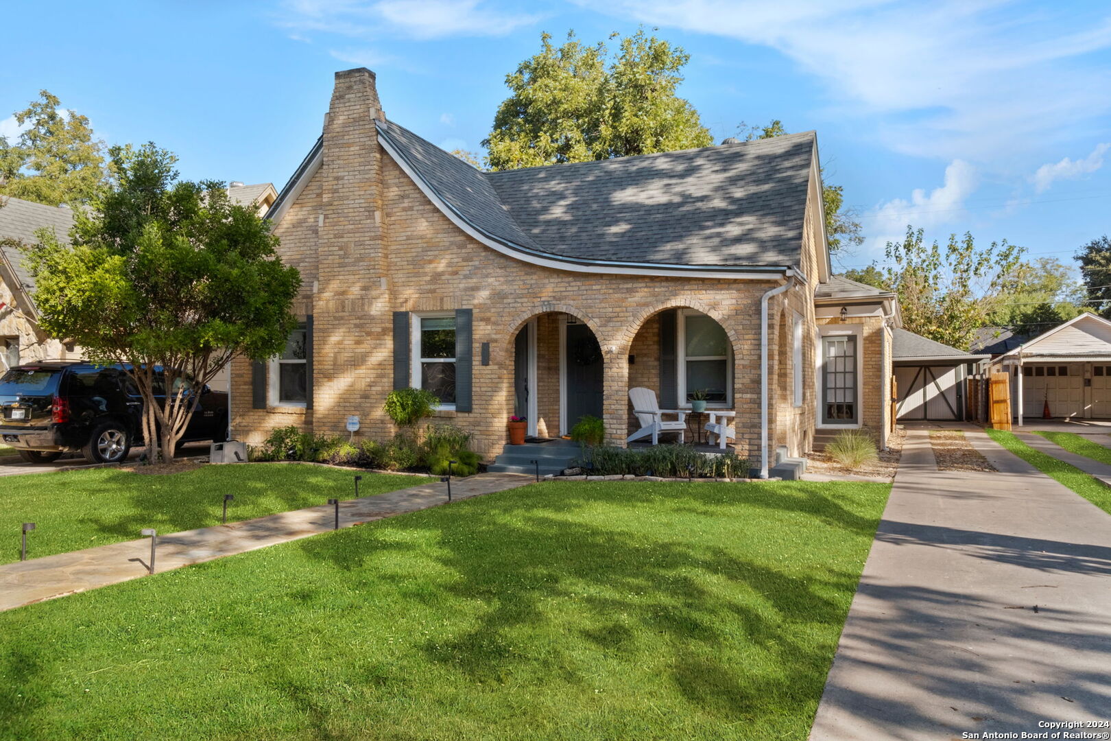 a front view of a house with a garden and plants