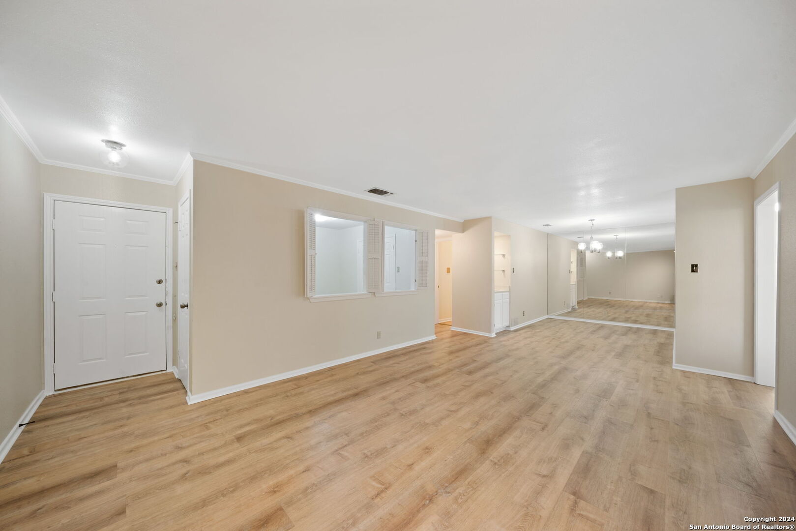 a view of an empty room with wooden floor