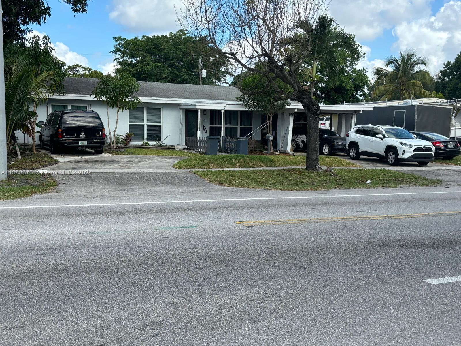 a car parked in front of house with a yard