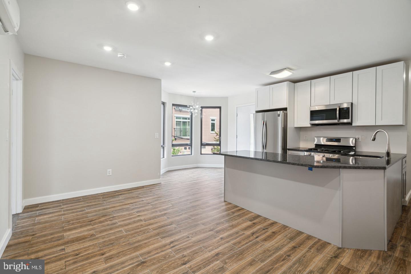 a large kitchen with cabinets wooden floor and stainless steel appliances