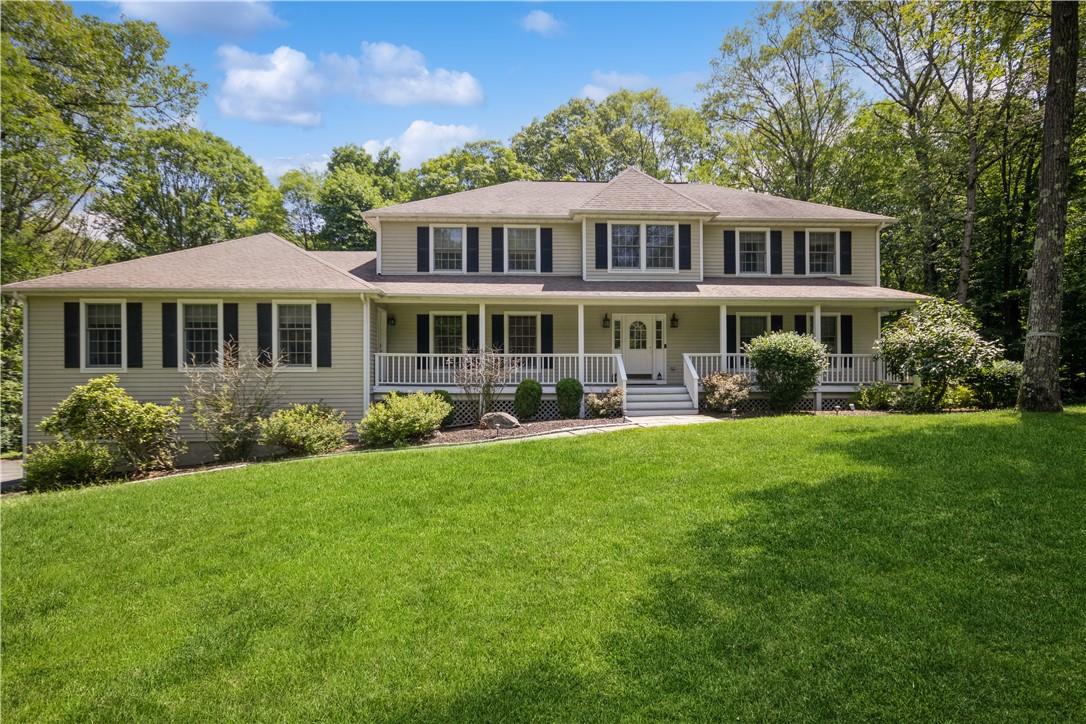 a front view of a house with garden and trees