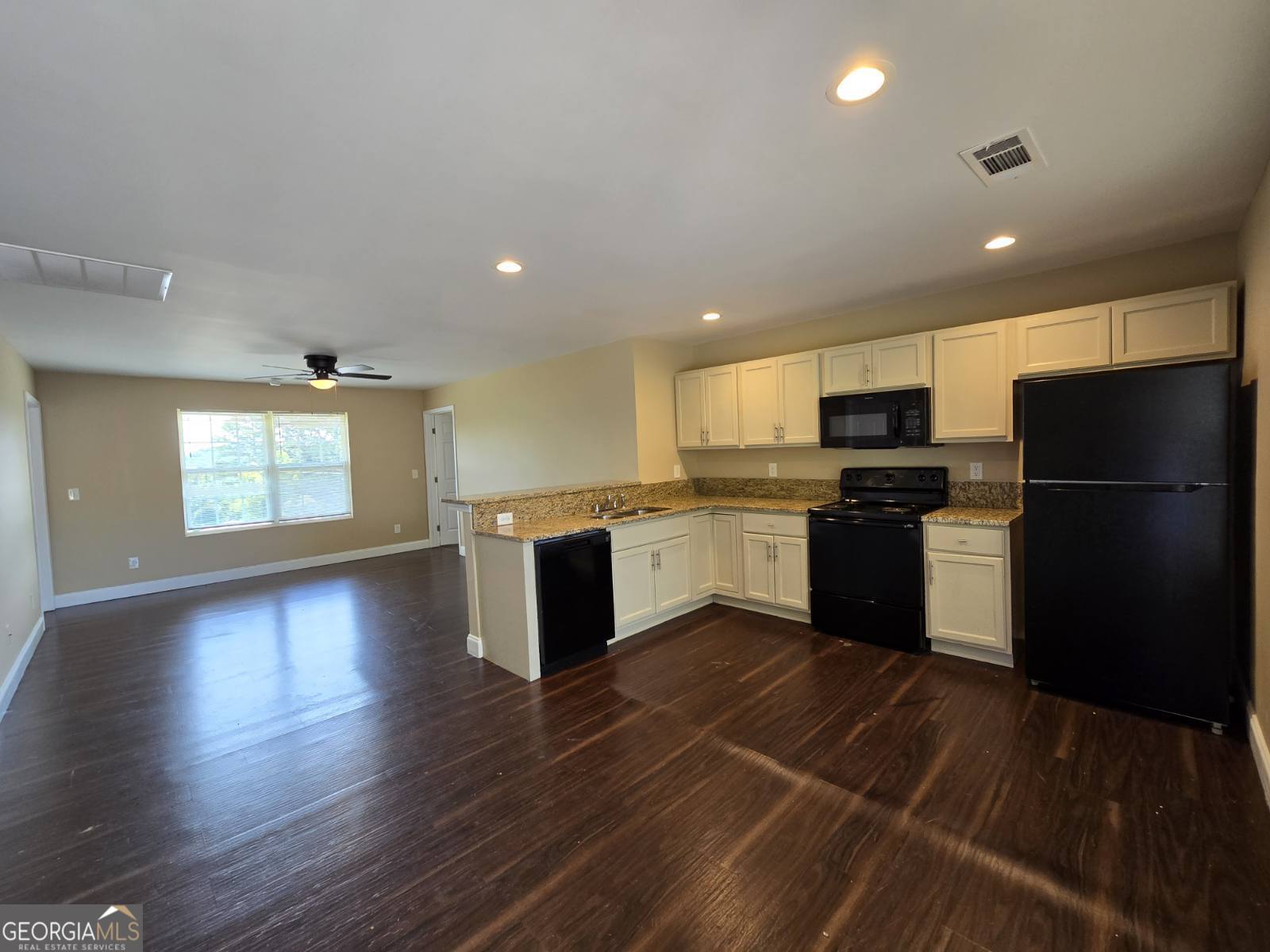 a kitchen with a refrigerator and a stove top oven