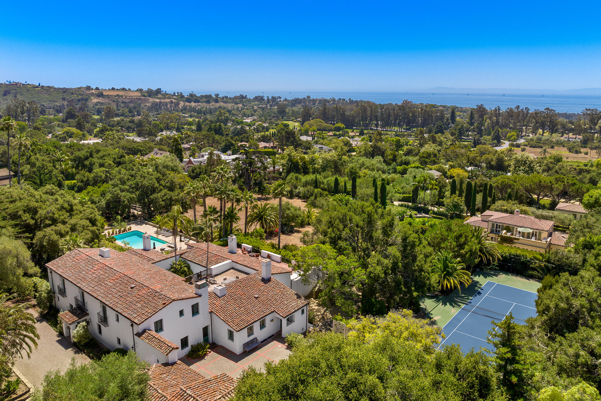 an aerial view of a house with a yard and mountain view in back