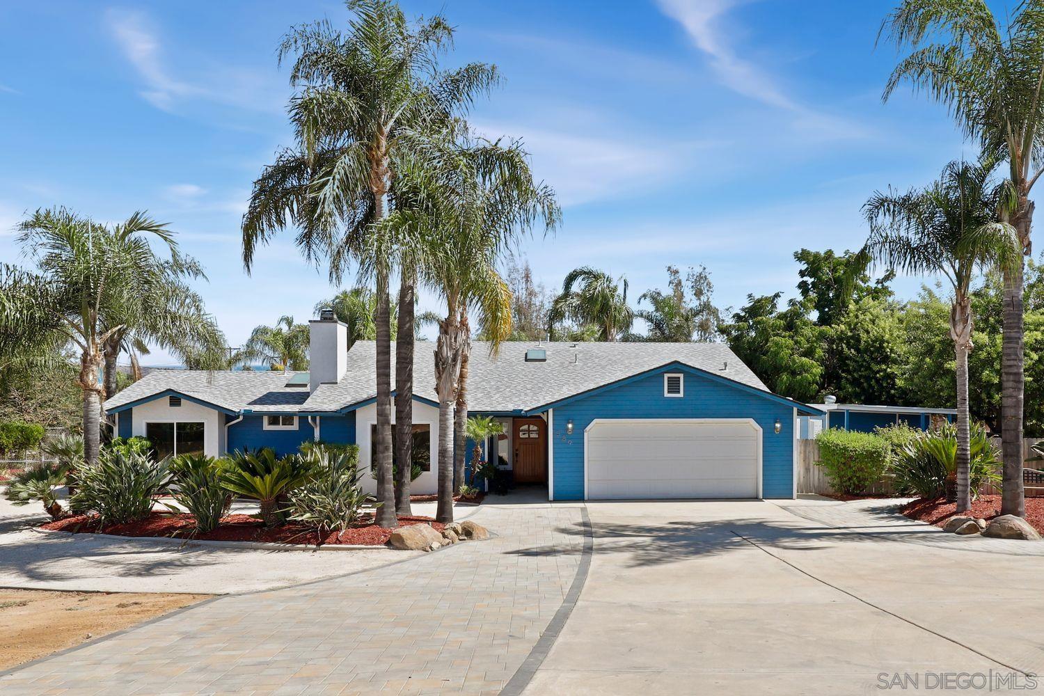 a front view of a house with garden and parking