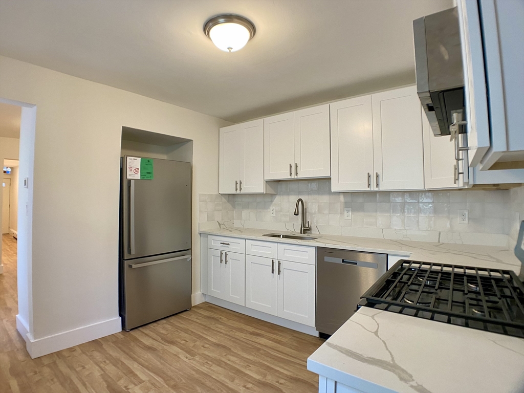 a kitchen with a sink a refrigerator and cabinets