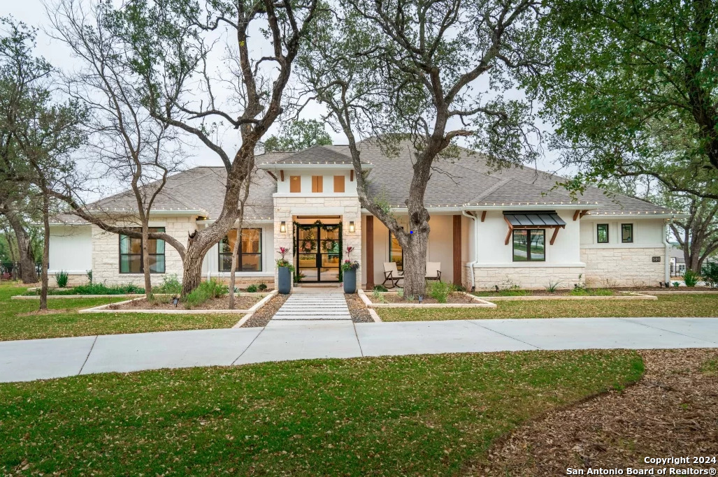 a view of a house with a big yard and large trees