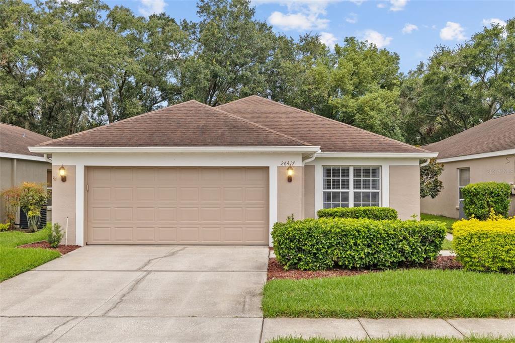 a front view of a house with a yard and garage