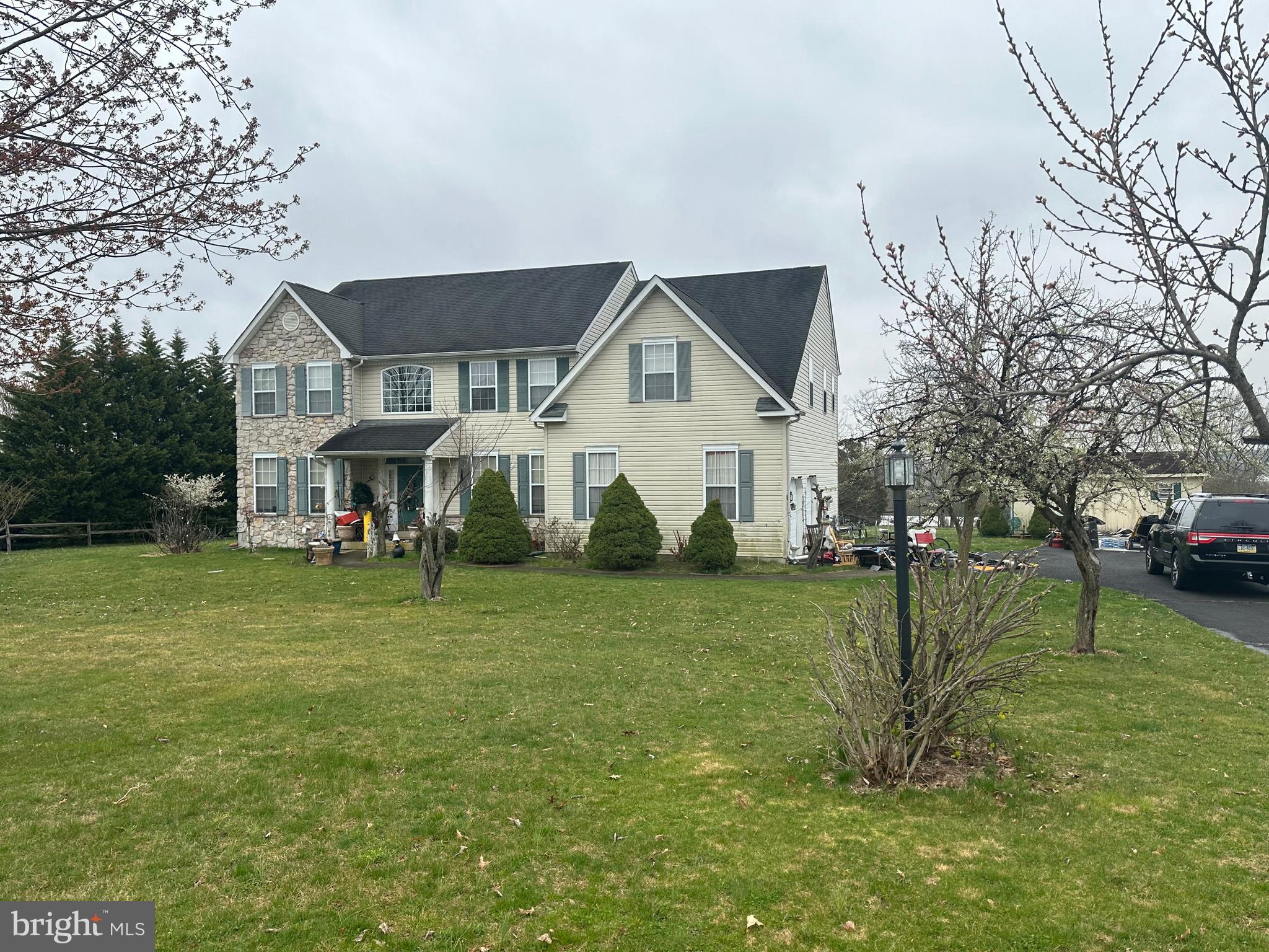 a view of a big house with a big yard and large trees