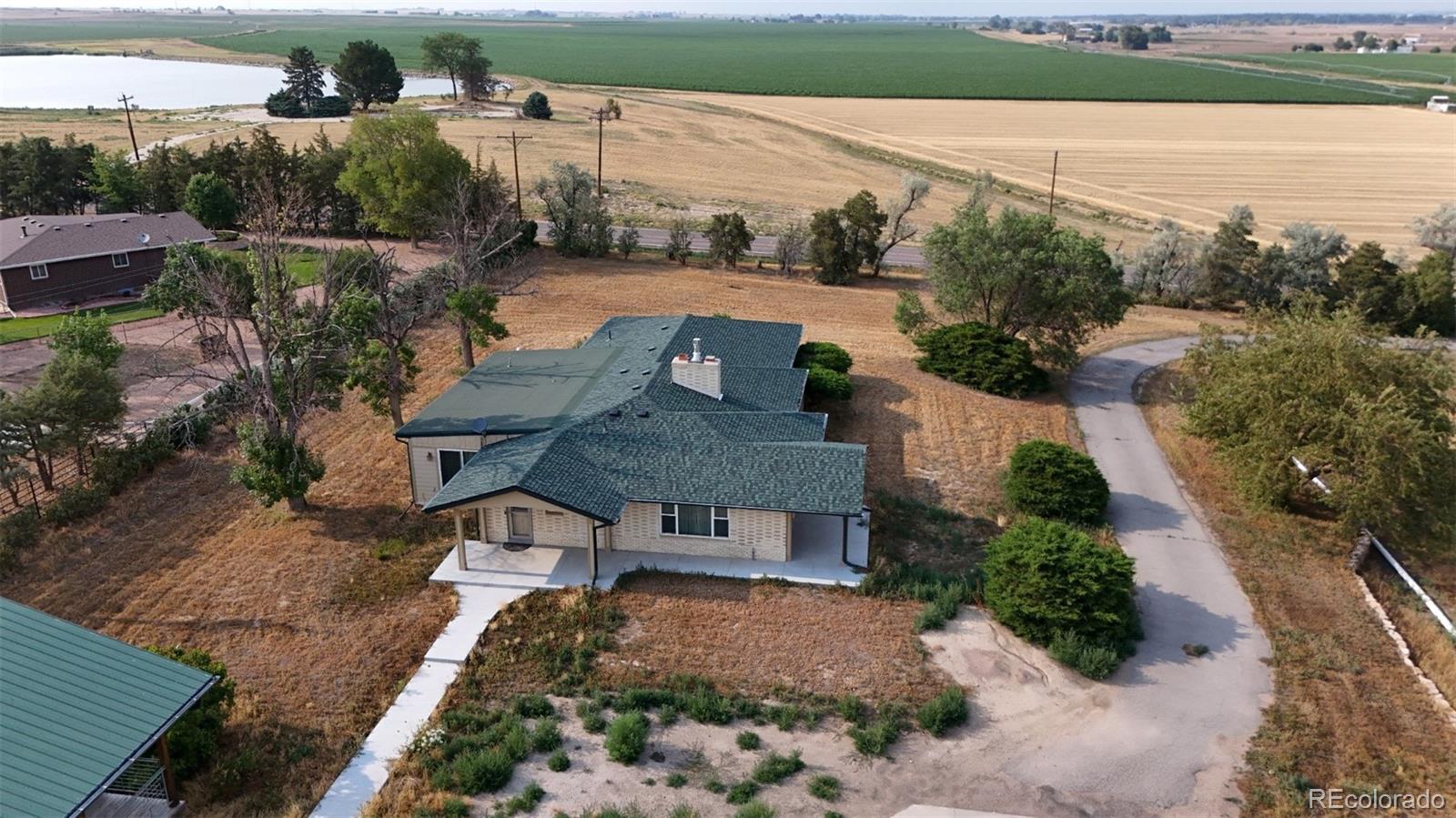 an aerial view of a house with a yard lake and outdoor seating