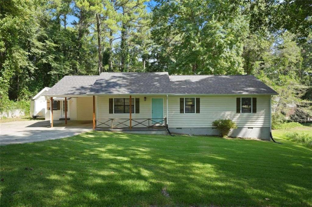 a front view of a house with a garden and trees