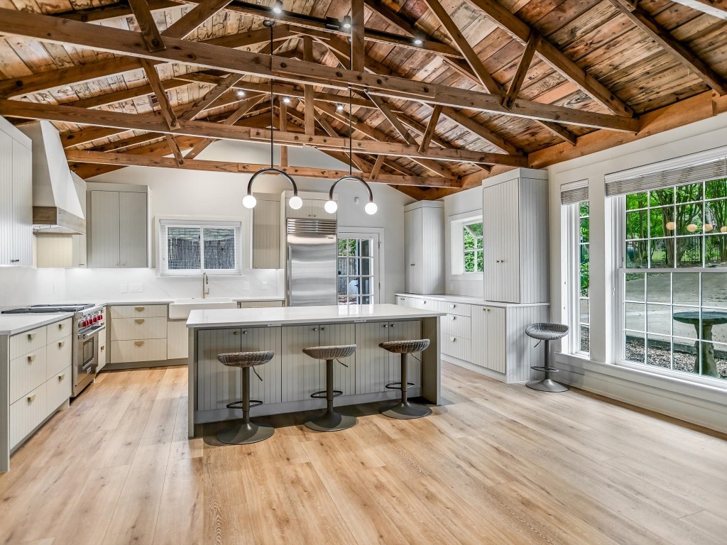 a view of a kitchen with stainless steel appliances granite countertop a sink and wooden floors