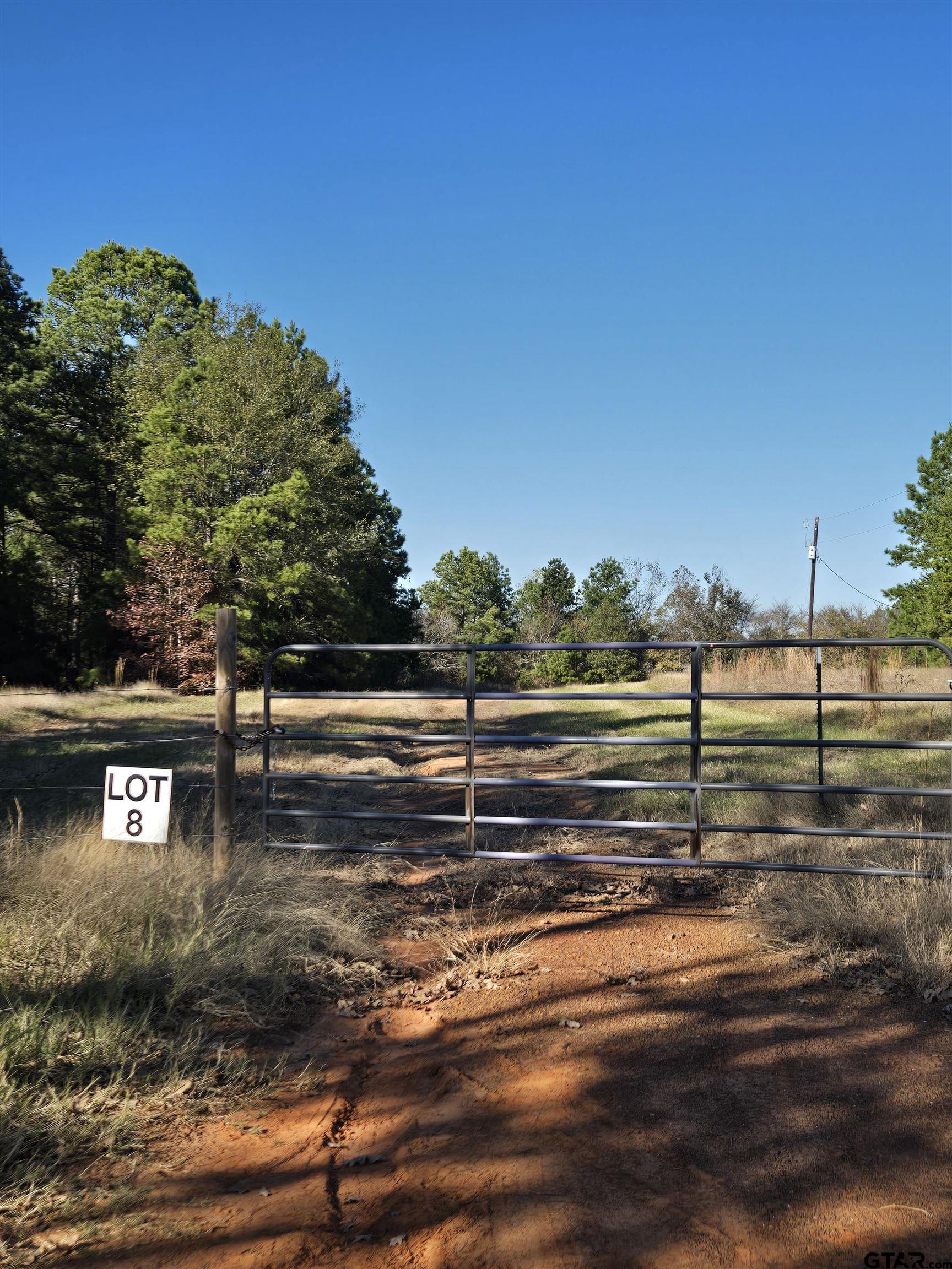 a view of a yard with wooden fence