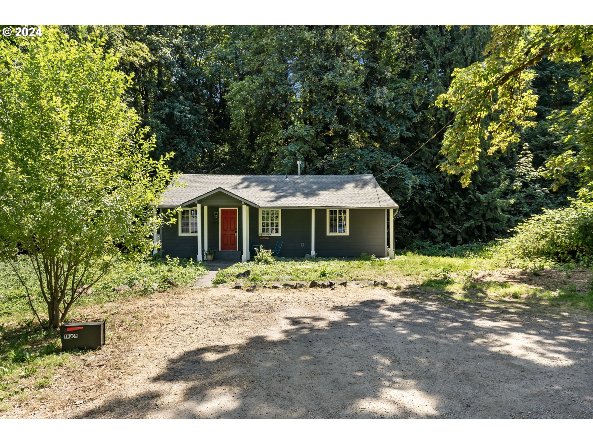 a wooden house with trees in the background