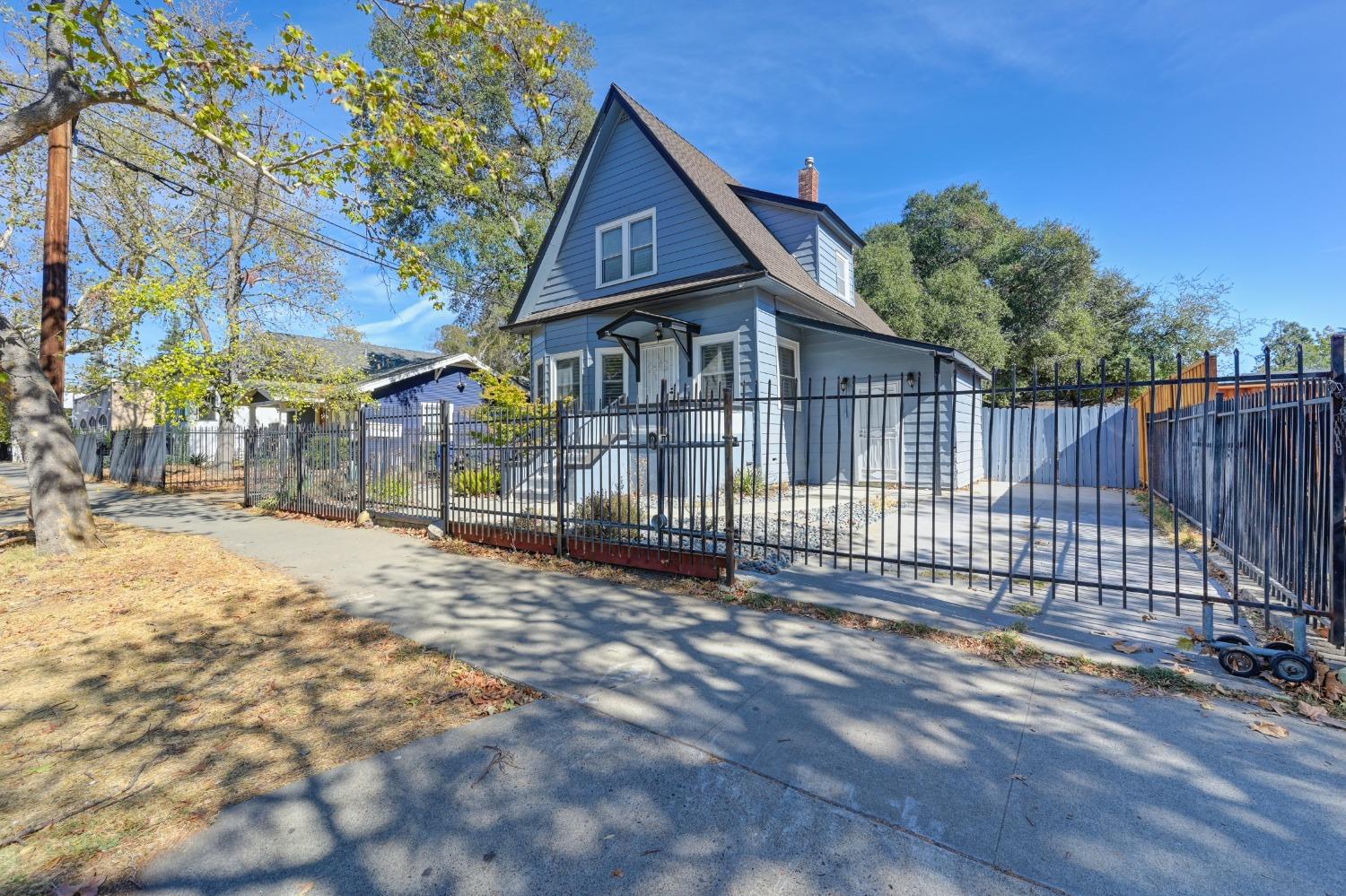 a view of a house with a small yard and wooden fence