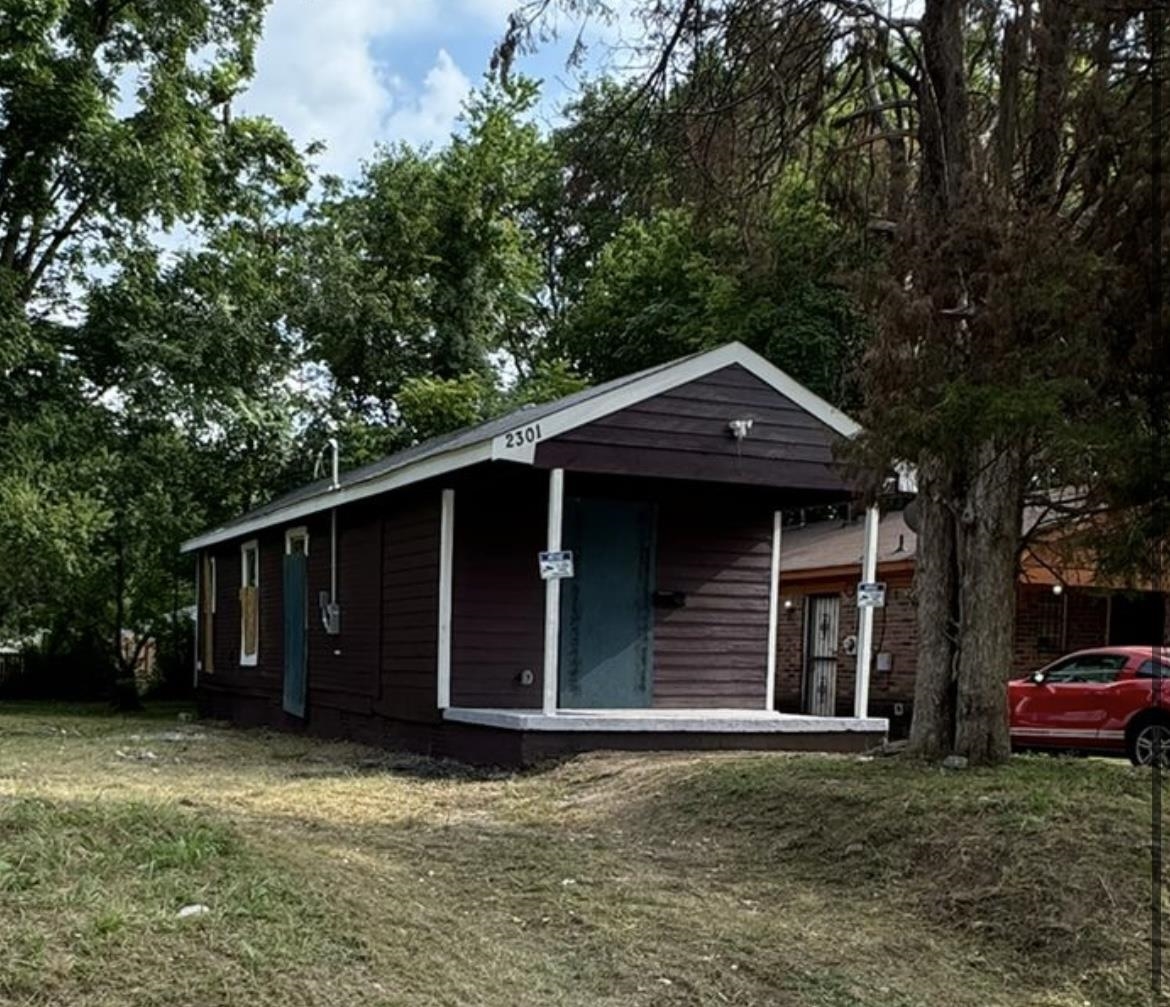 View of outdoor structure featuring a lawn