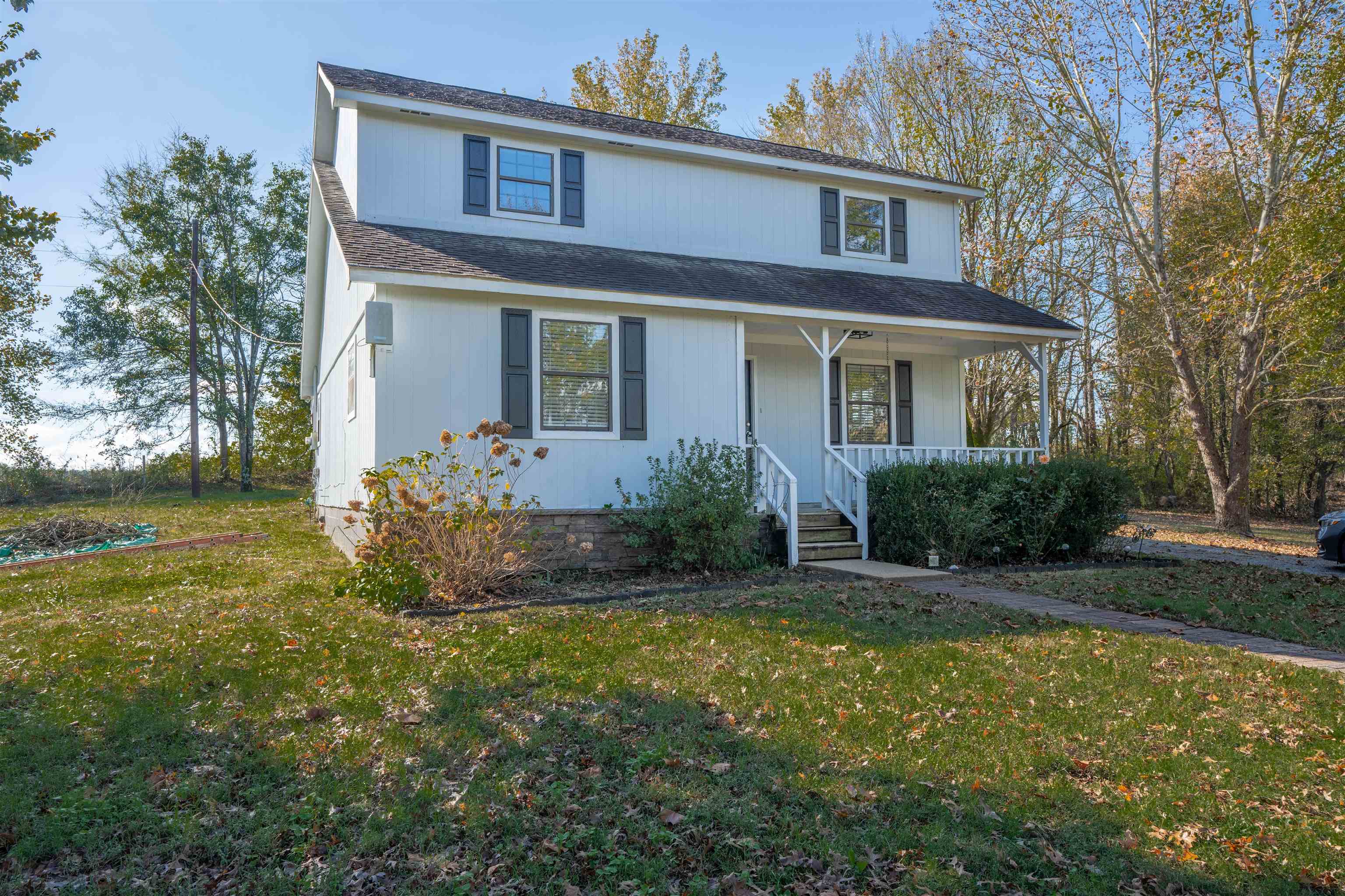 Front of property with covered porch and a front yard