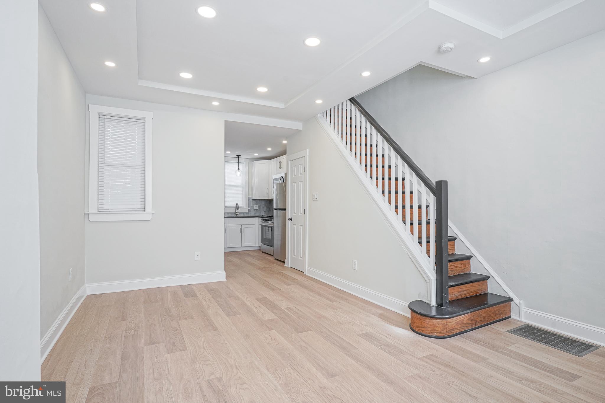 a view of a hallway with wooden floor and staircase