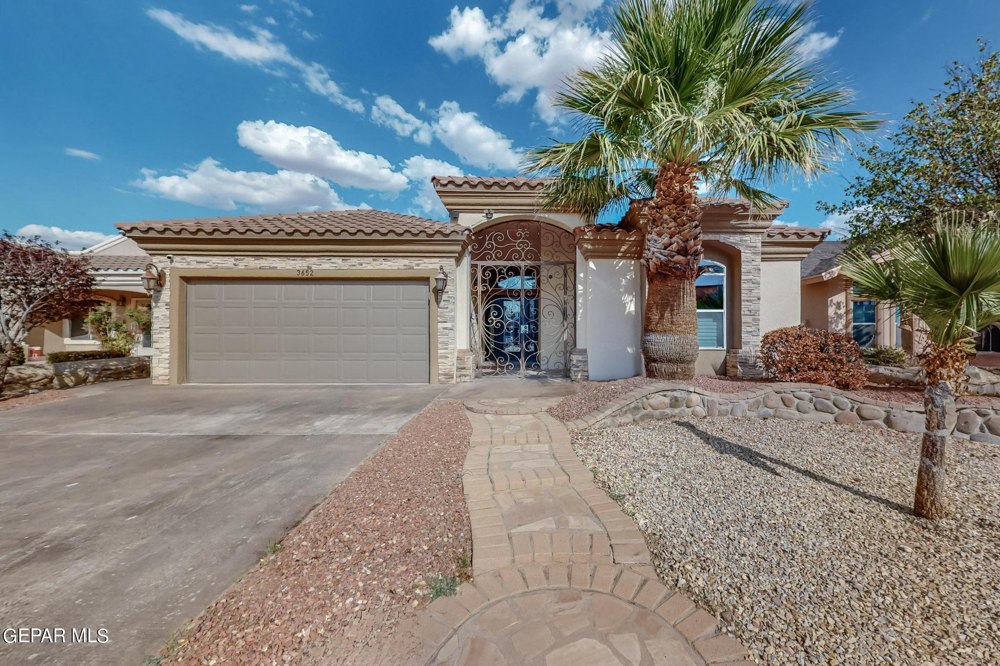 a view of a house with a yard and palm trees