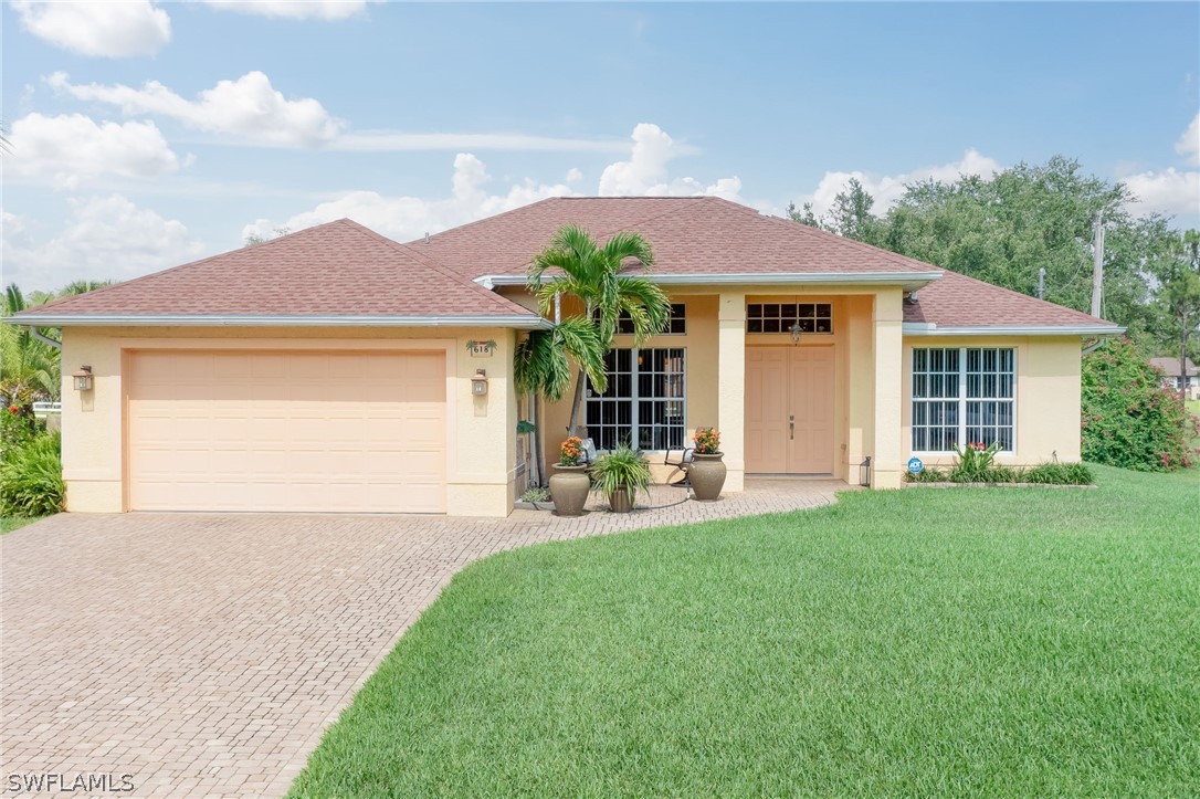 a front view of a house with a garden and yard