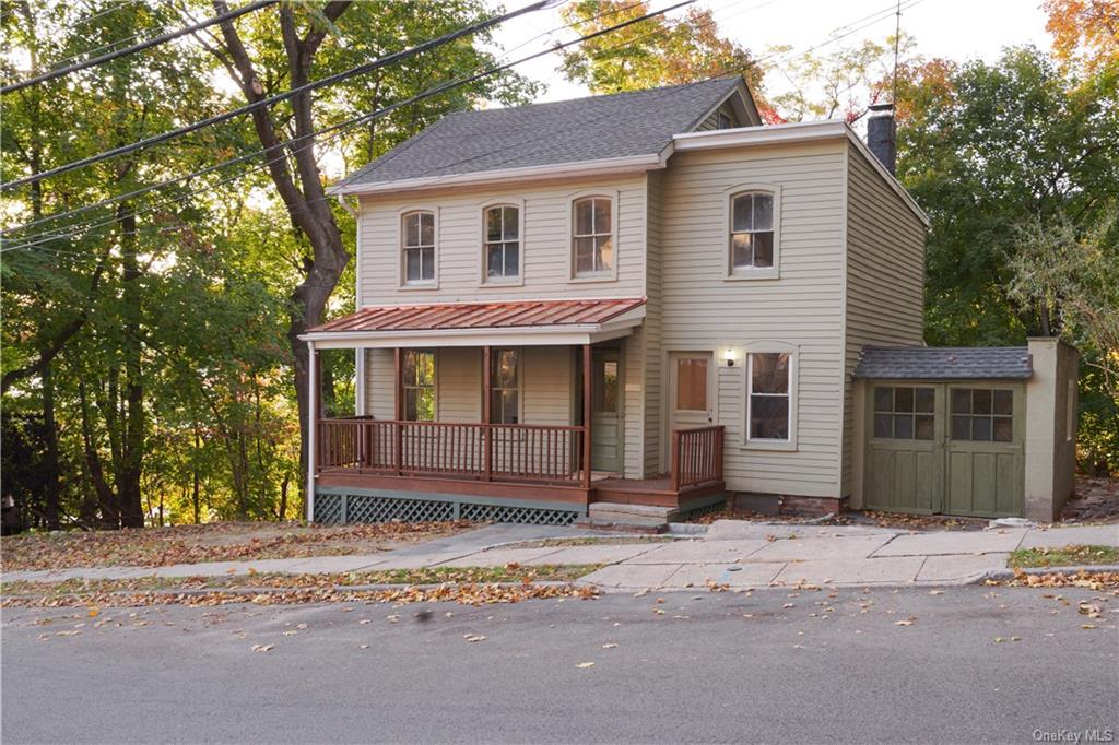 View of front facade featuring the garage and the porch.