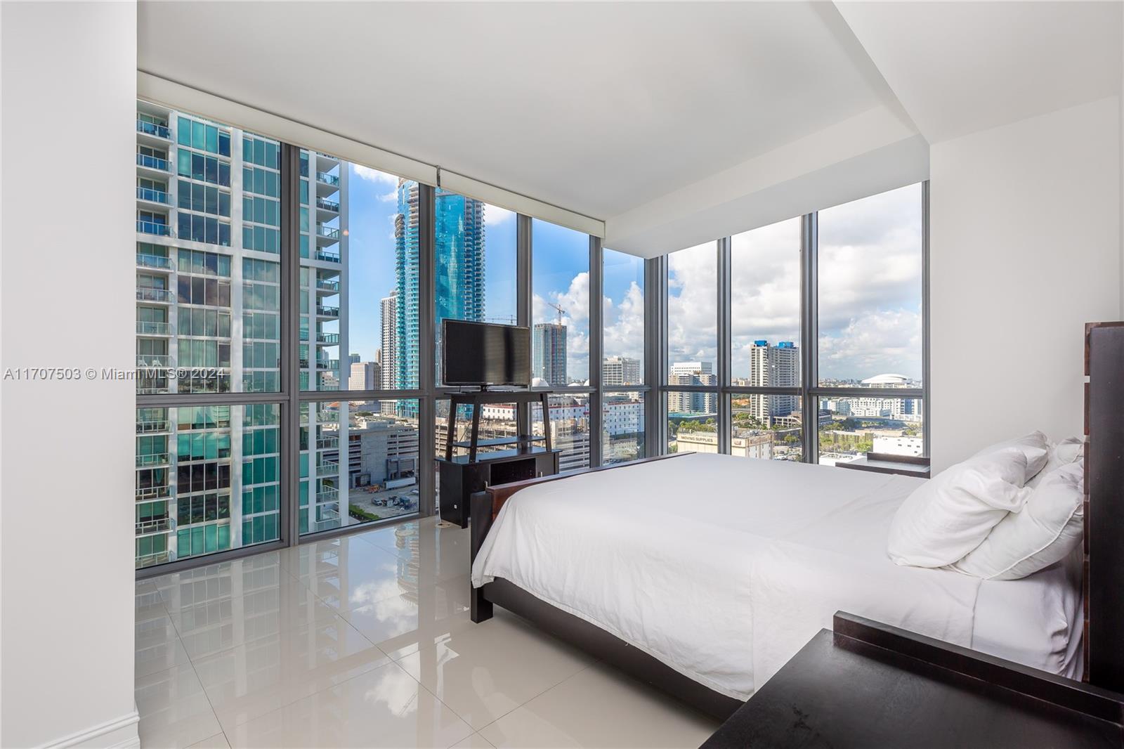 a large bedroom with a bed and glass door