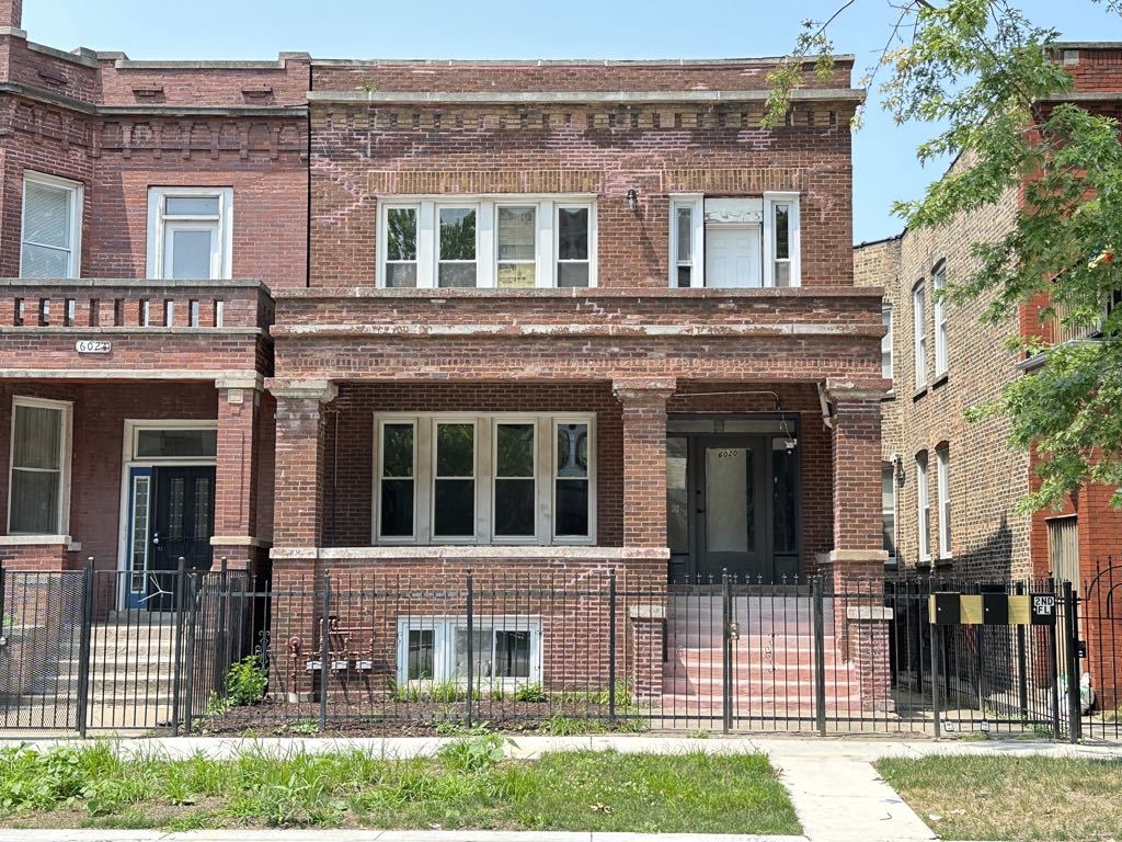 front view of a brick house with a yard