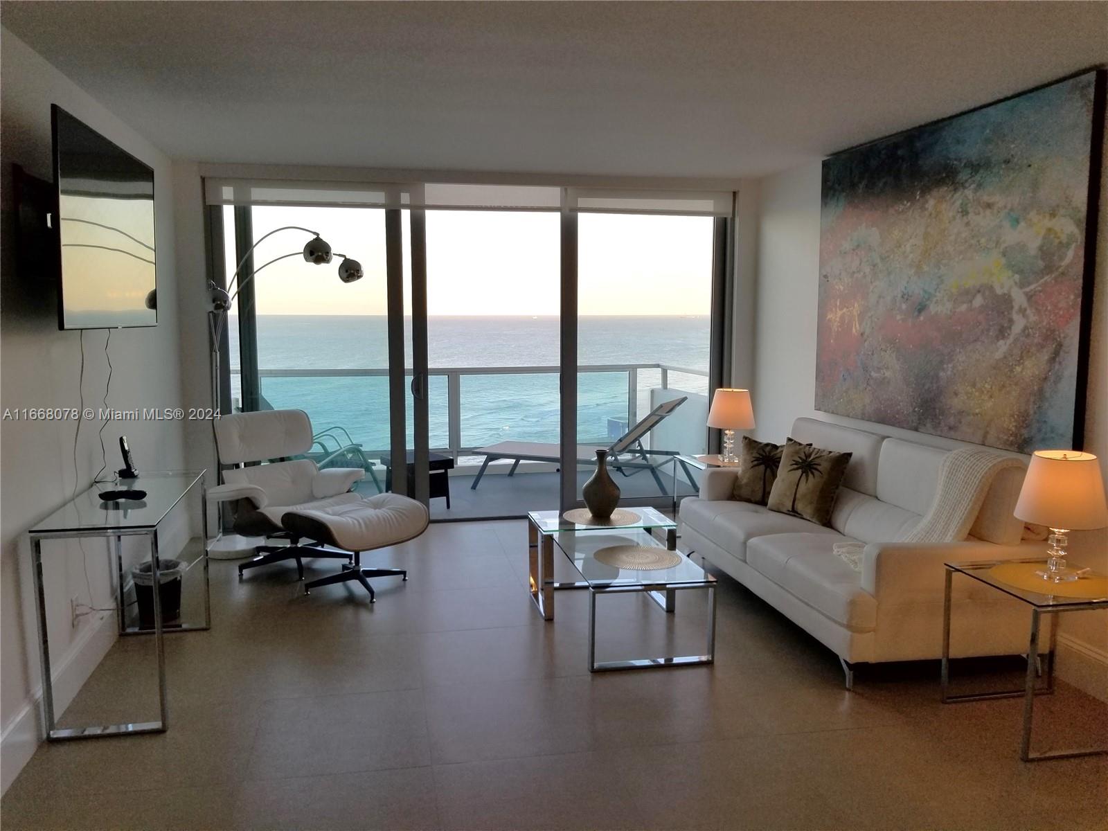 a living room with furniture and floor to ceiling window