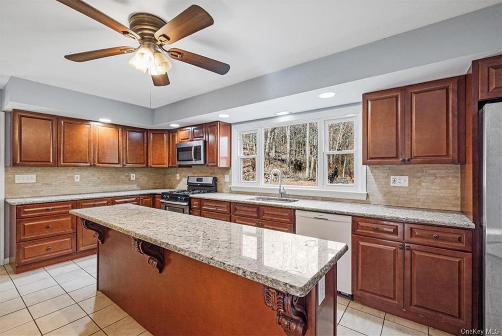 a kitchen with stainless steel appliances granite countertop a sink and dishwasher a stove top oven with wooden floor