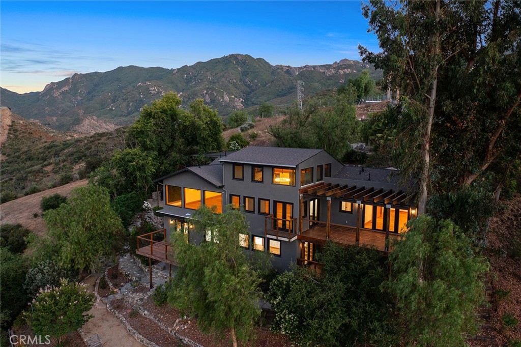 a front view of a house with a yard and mountain view