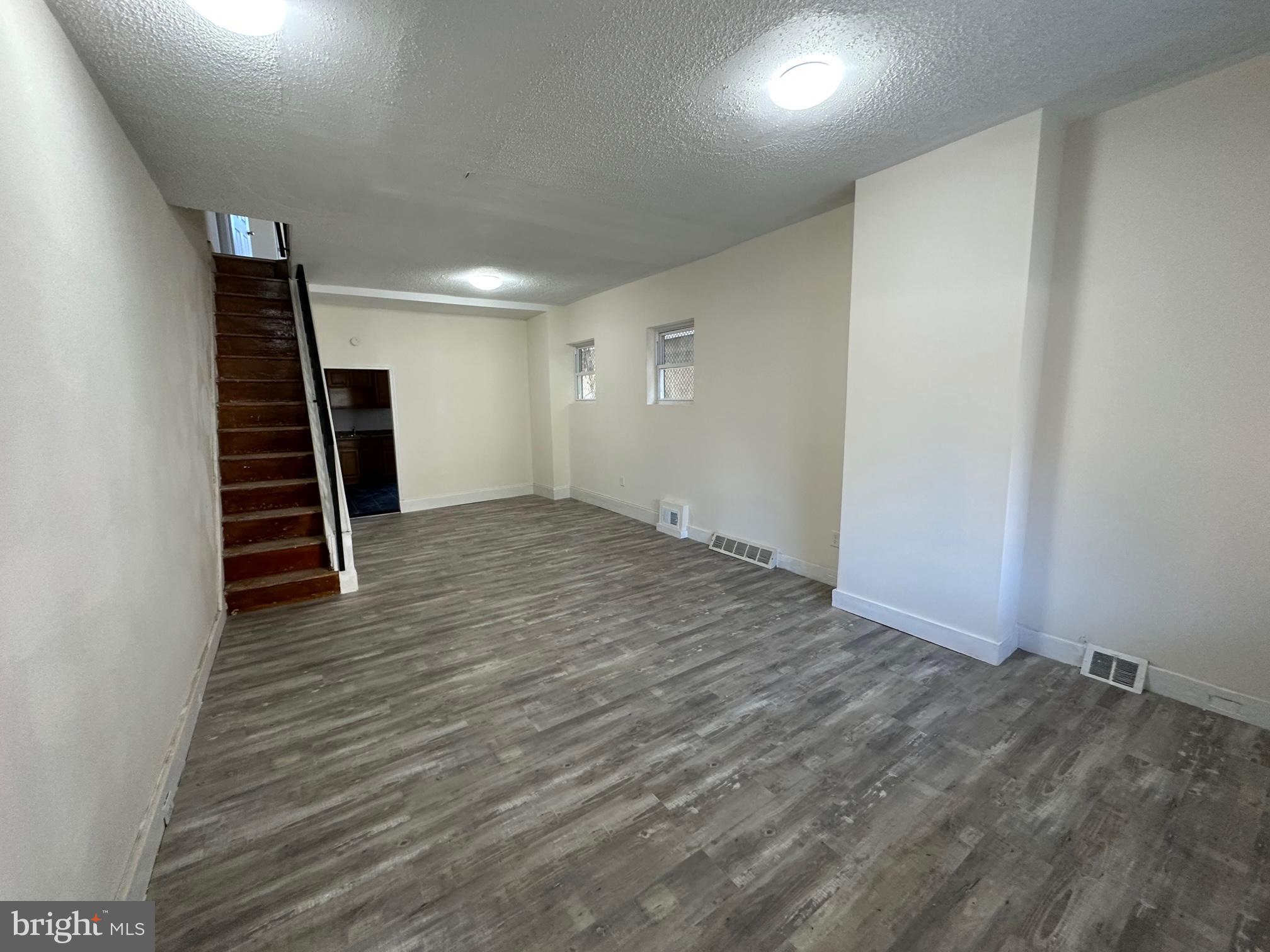 an empty room with wooden floor and stairs