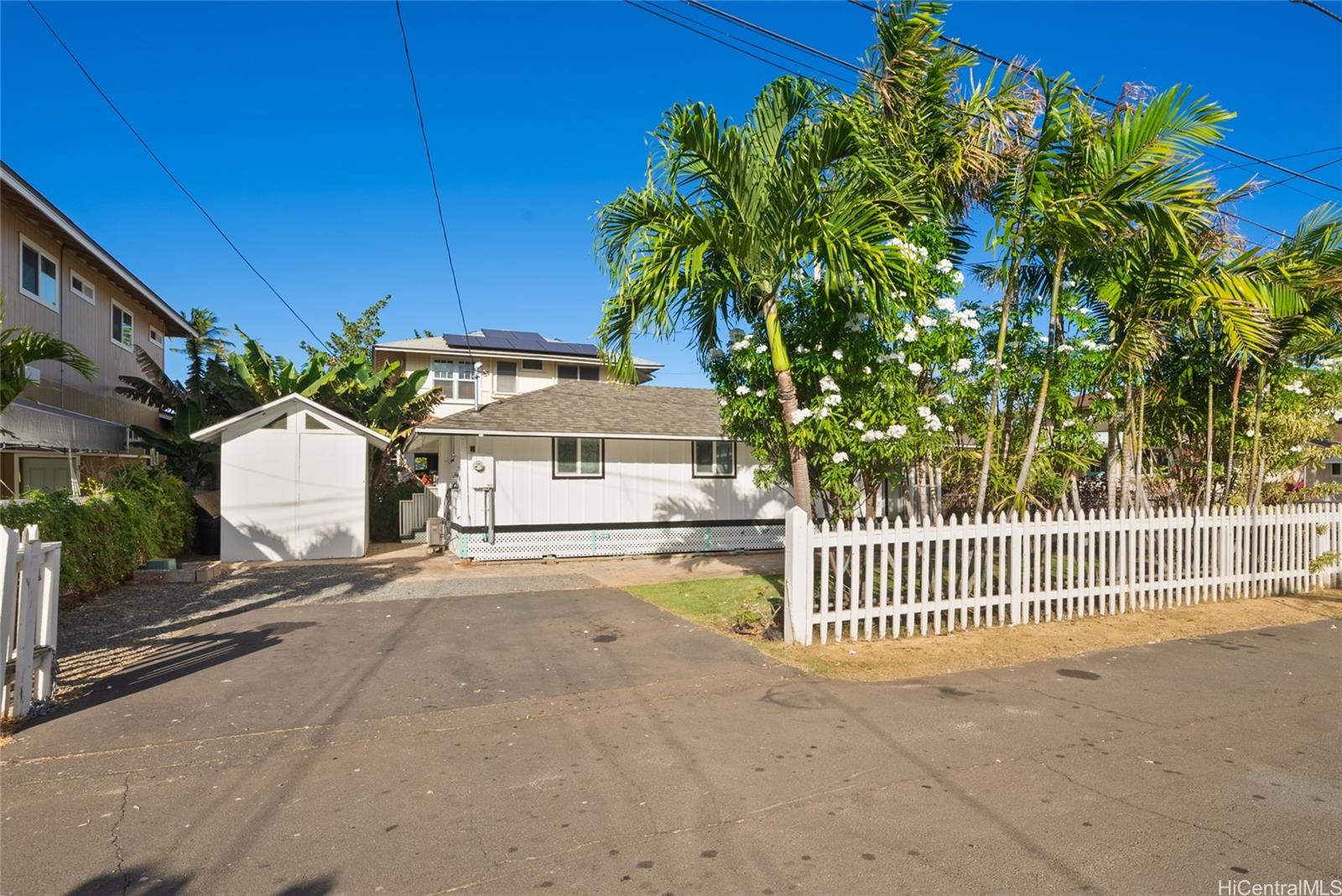 a view of a house with a small yard and wooden fence