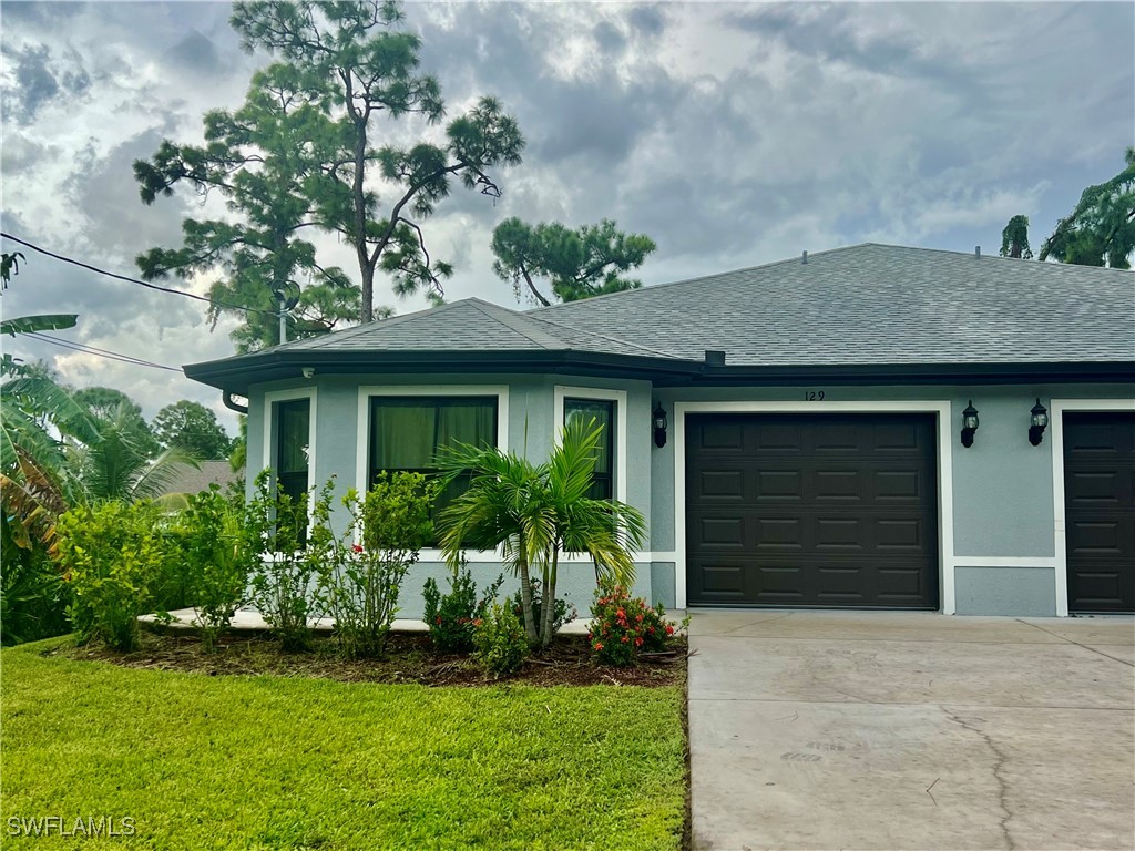 a front view of a house with a yard and garage