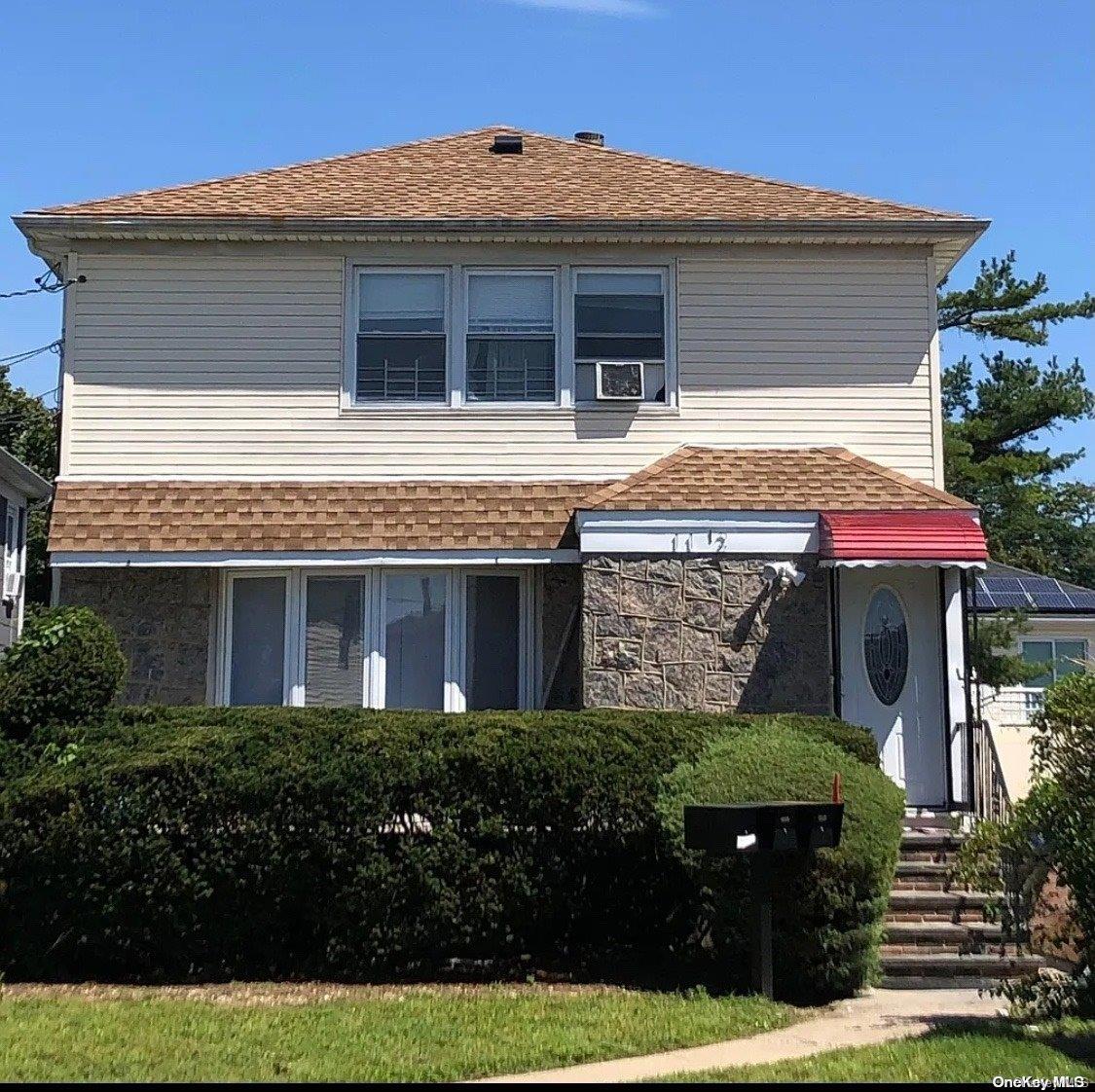 a front view of a house with a garden