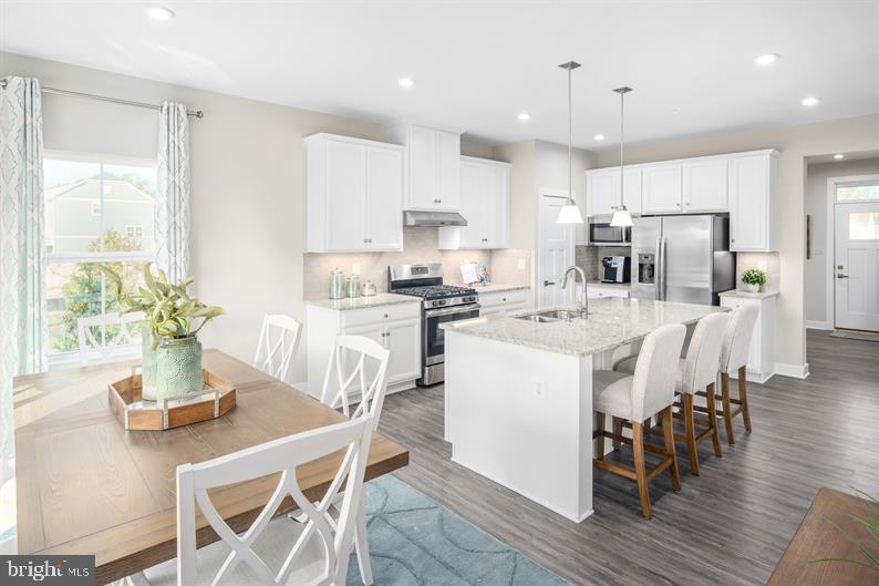 a kitchen with kitchen island a stove a dining table and chairs