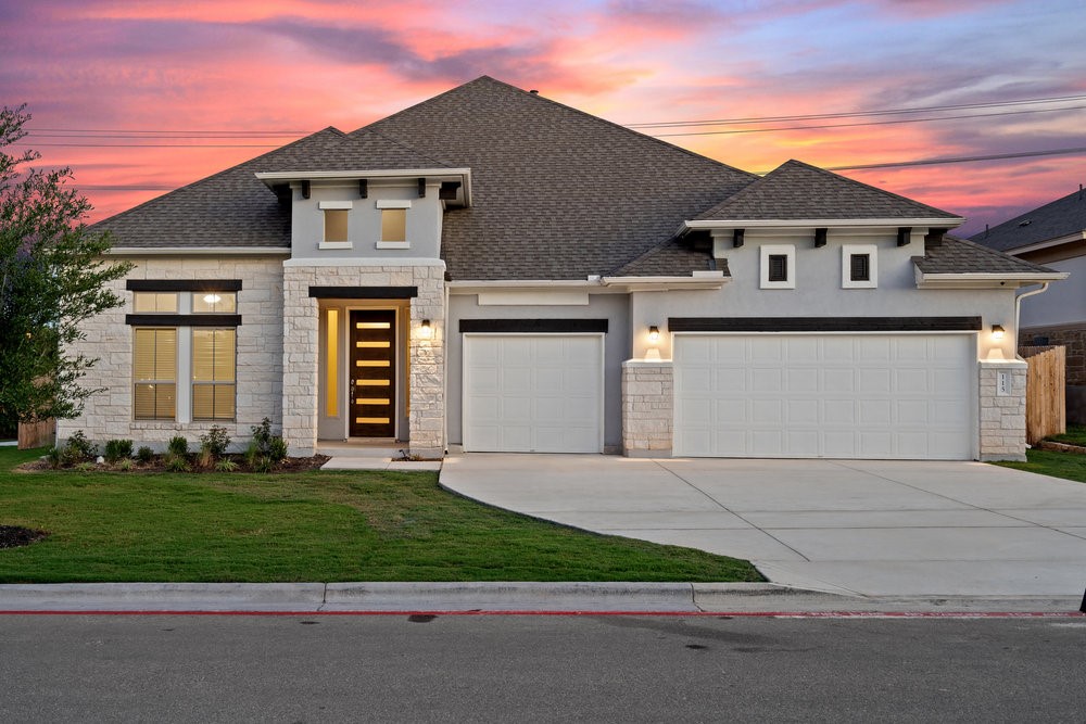 a front view of a house with a garden and garage