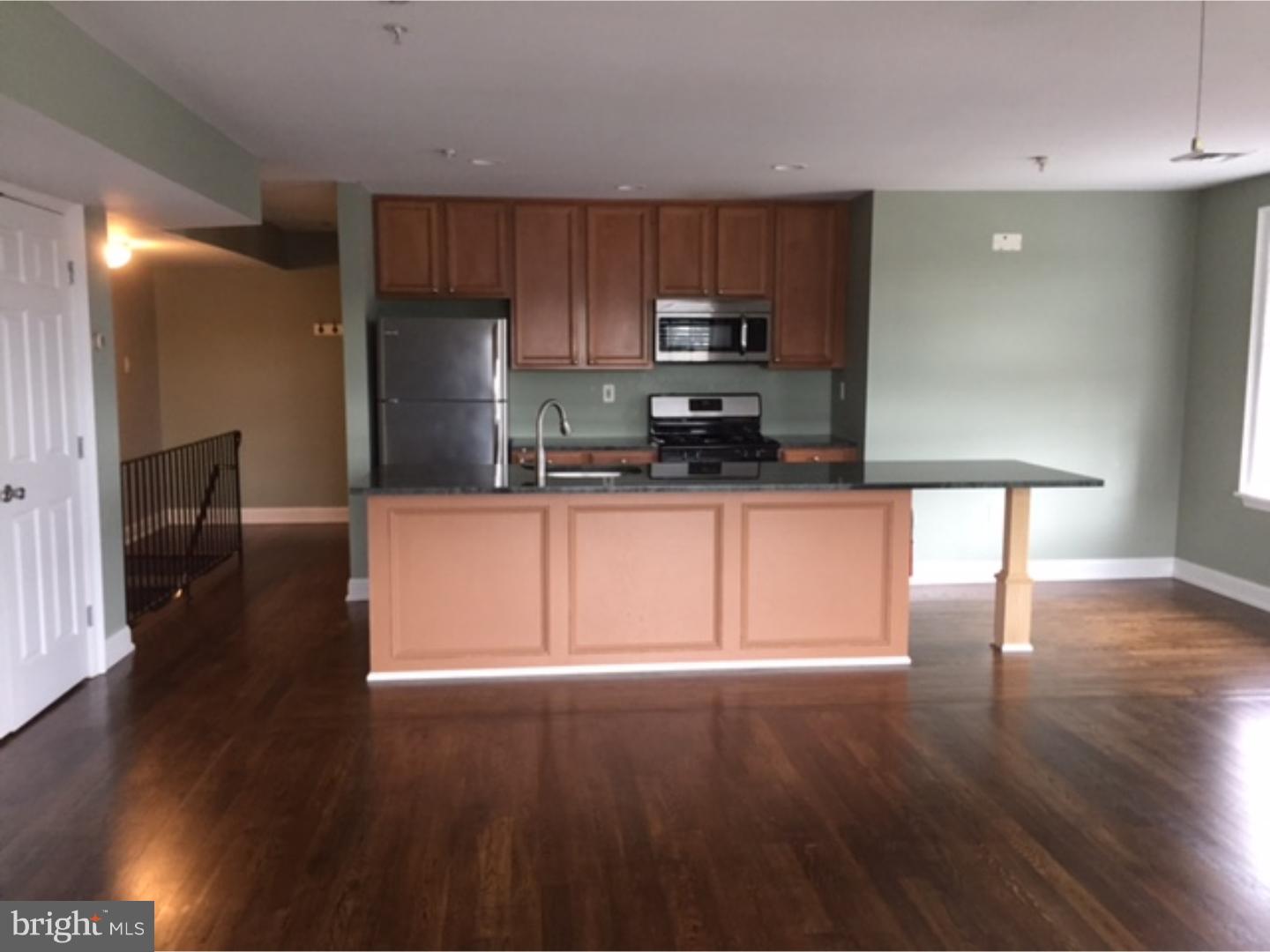 a kitchen with granite countertop wooden floors stainless steel appliances and cabinets