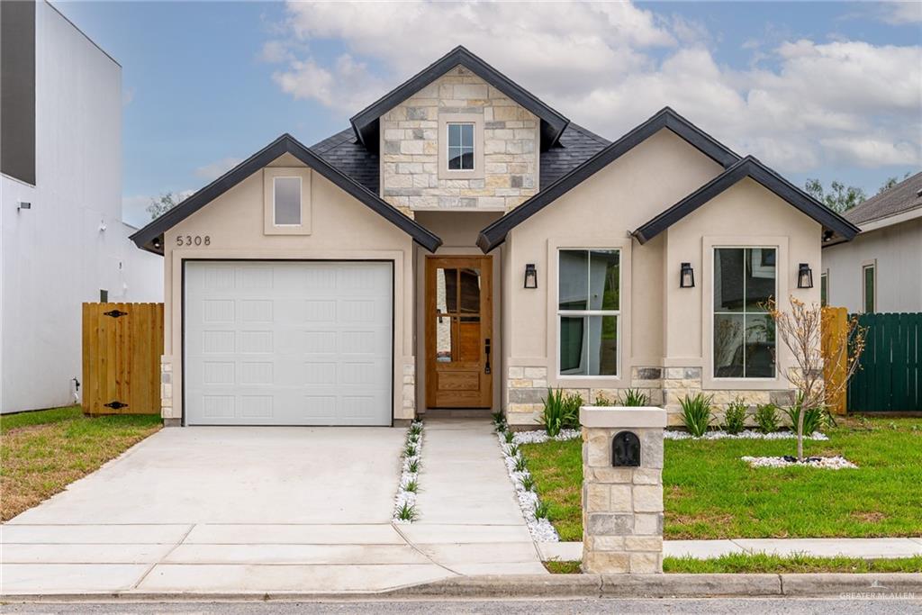 View of front facade featuring a garage and a front yard