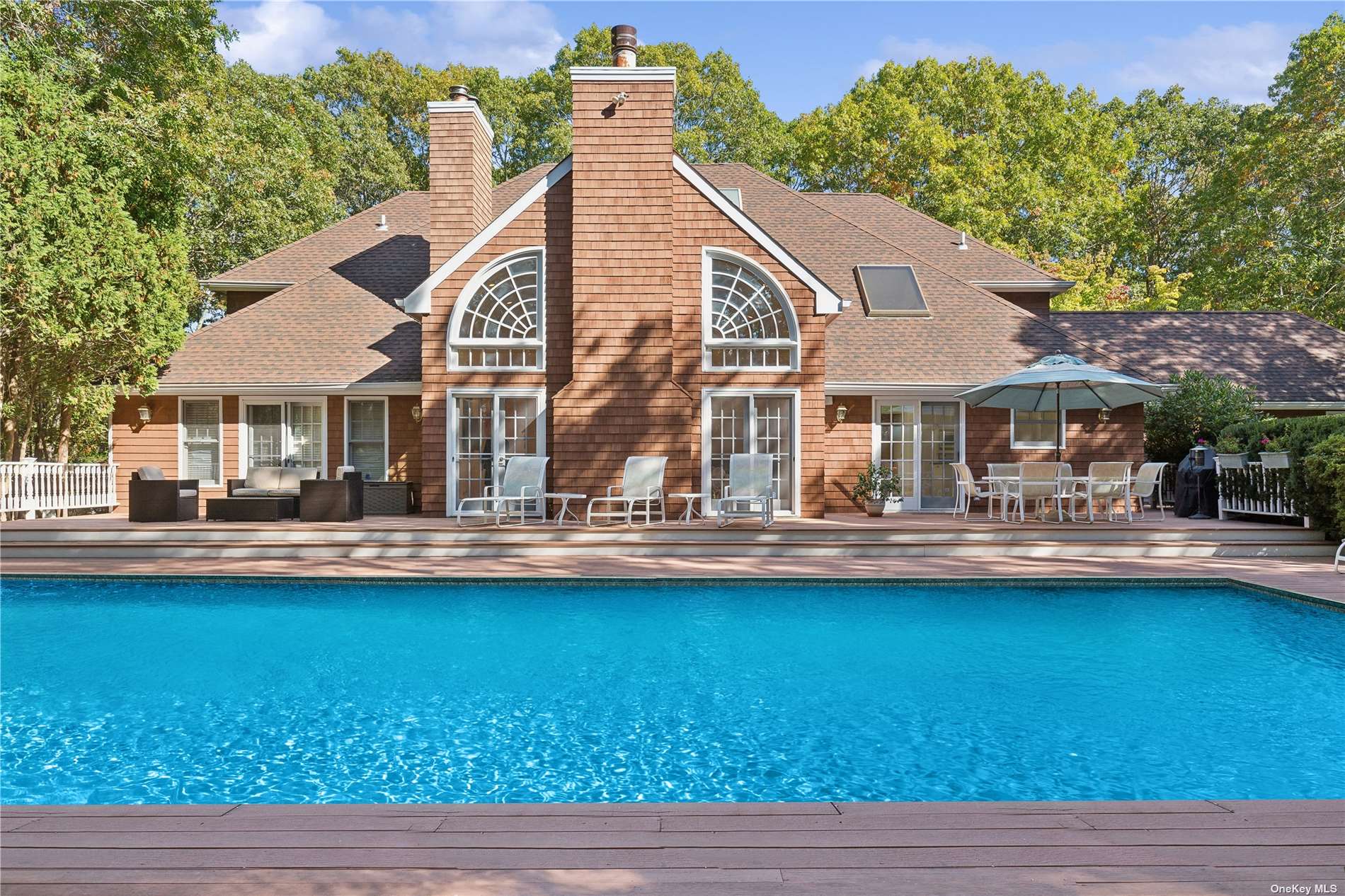 a front view of a house with swimming pool having outdoor seating