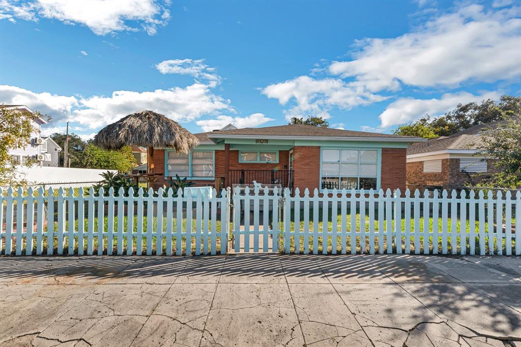 a view of a house with a small yard and wooden fence